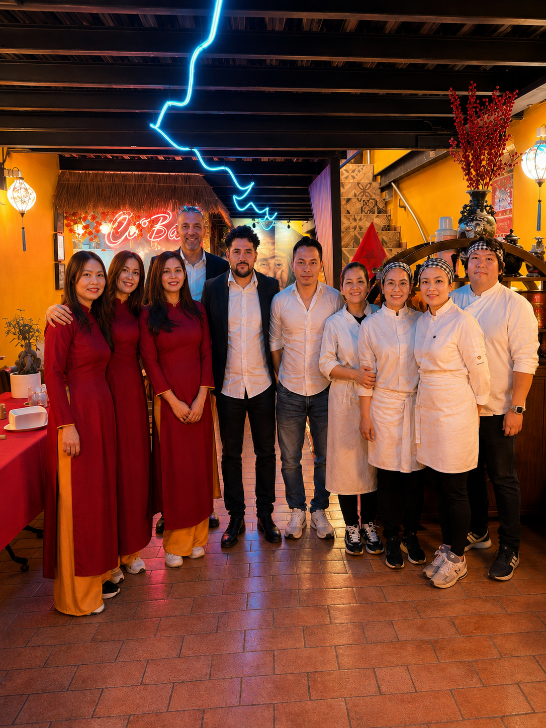 Équipe de serveurs et cuisiniers accueillant les clients au restaurant Cô Bảy.
